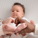 baby girl feet in parents hands heart shape
